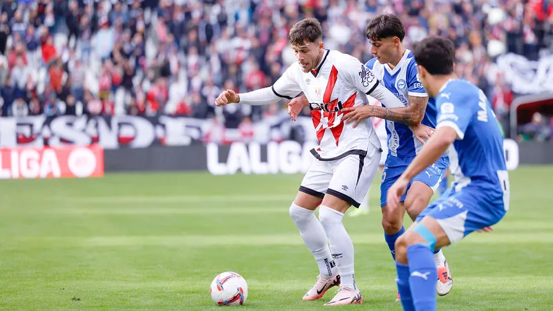 Cầu thủ Real Avila chạy nhanh với bóng trước áp lực từ cầu thủ Rayo Vallecano.