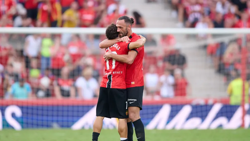 Cầu thủ của Real Oviedo sử dụng kỹ thuật đi bóng qua cầu thủ Mallorca trước khán đài đầy…